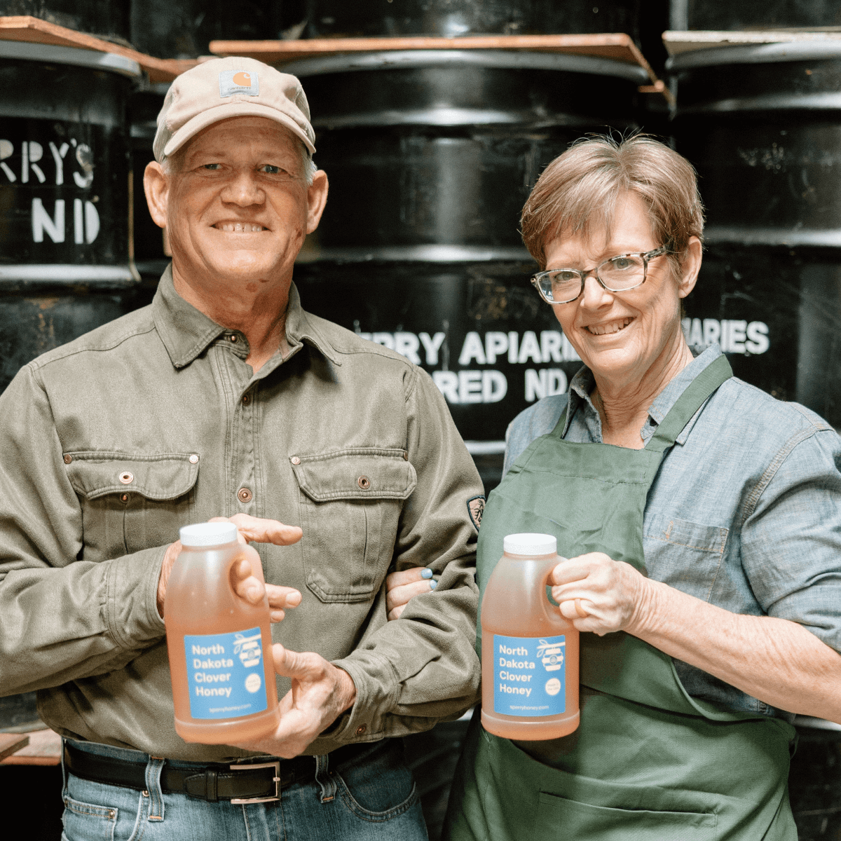 Mark and Rebecca Sperry holding bottles of clover honey.