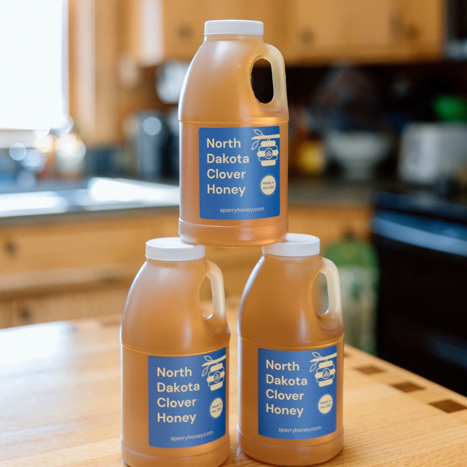 Three jars of clover honey stacked on top of each other.