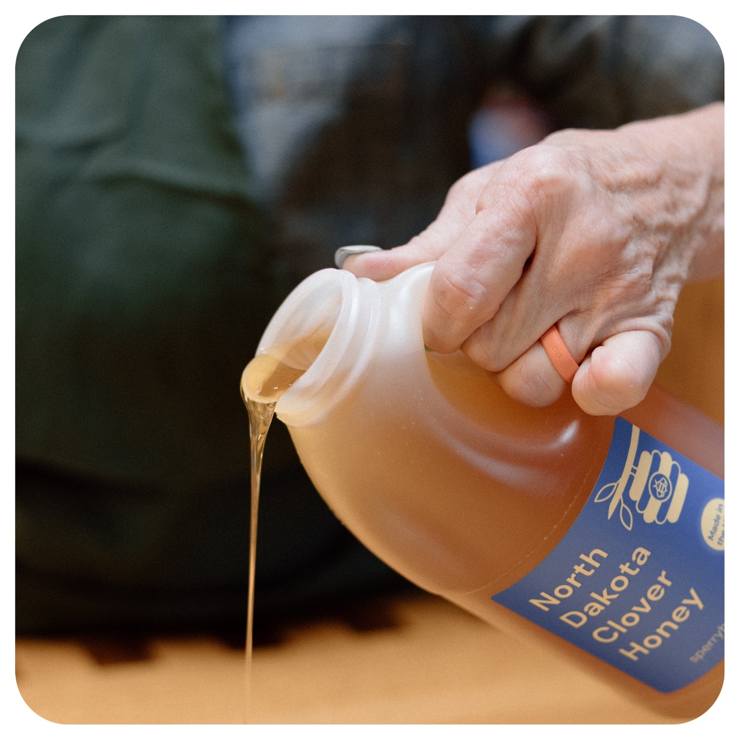 Becca Sperry pouring a jar of honey