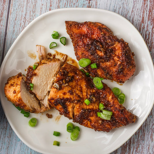 A plate of honey garlic chicken with chopped green onions for garnish.