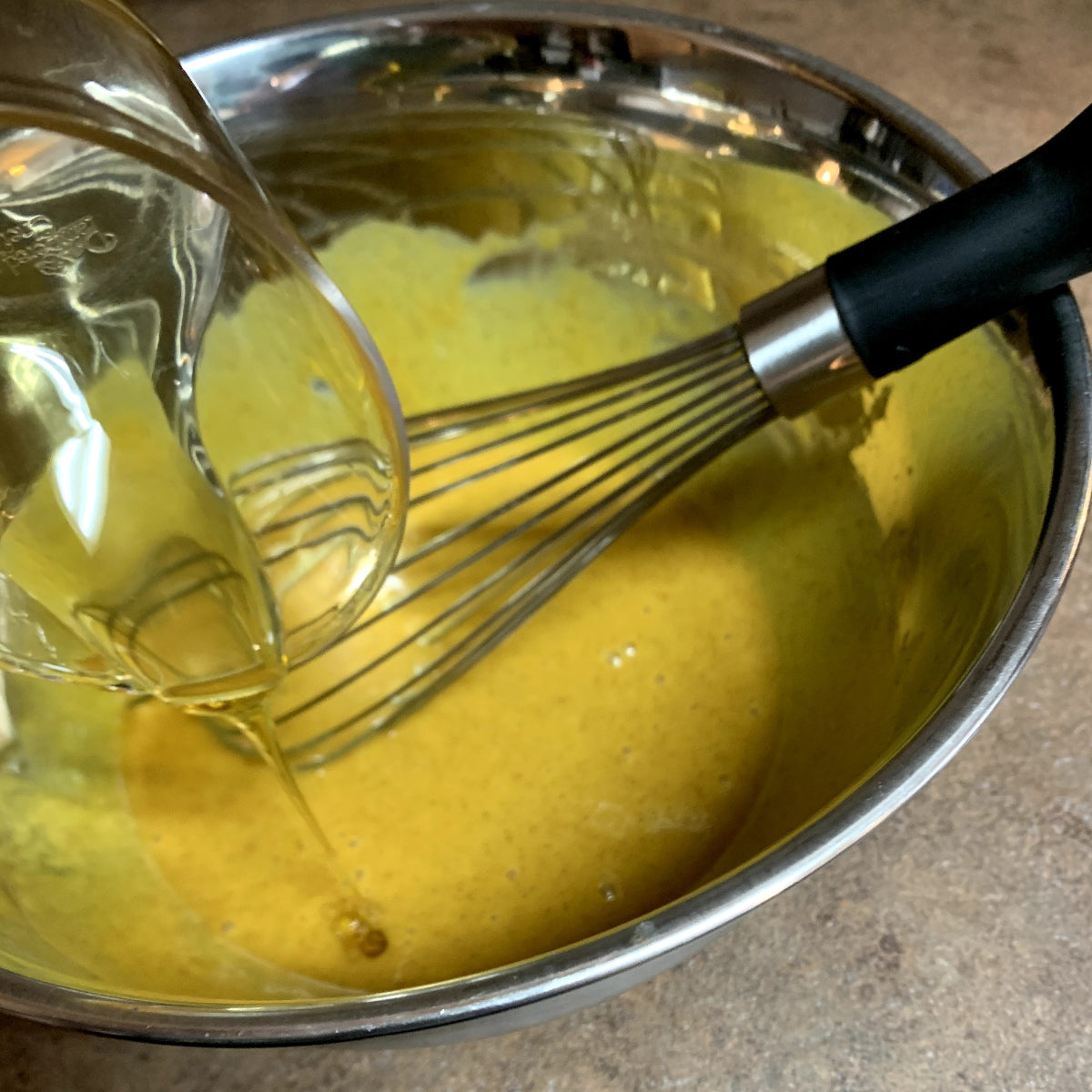 Pouring extra honey into the bowl of honey gold sauce.