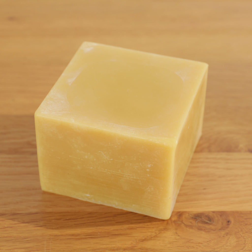 Block of beeswax on a wooden surface
