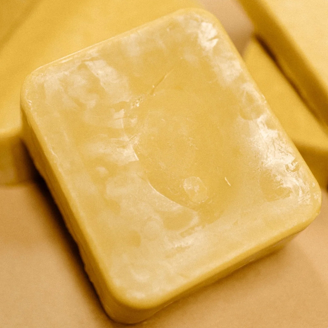 A beeswax blocks propped up against other beeswax blocks.