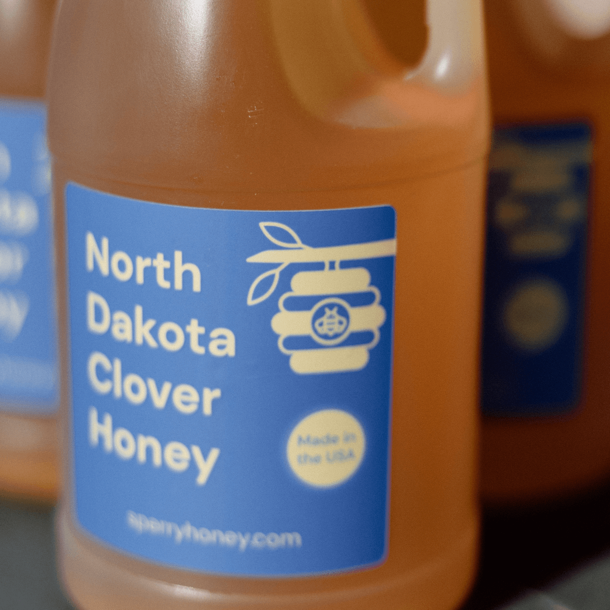 A closeup photo of three bottles of clover honey.