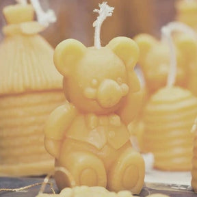 Yellow bear-shaped candle among other candles.