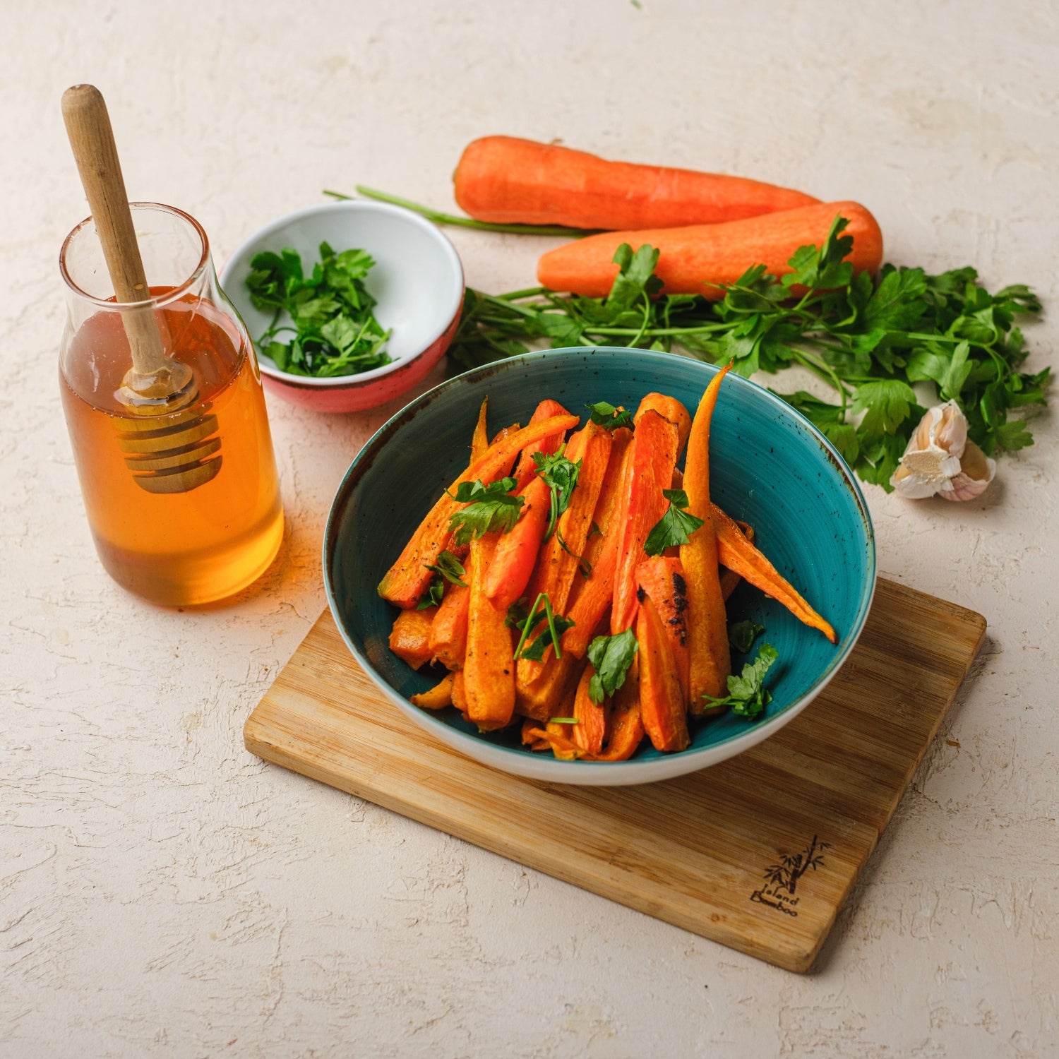 Photo of honey glazed carrots in a blue bowl with honey and thyme.