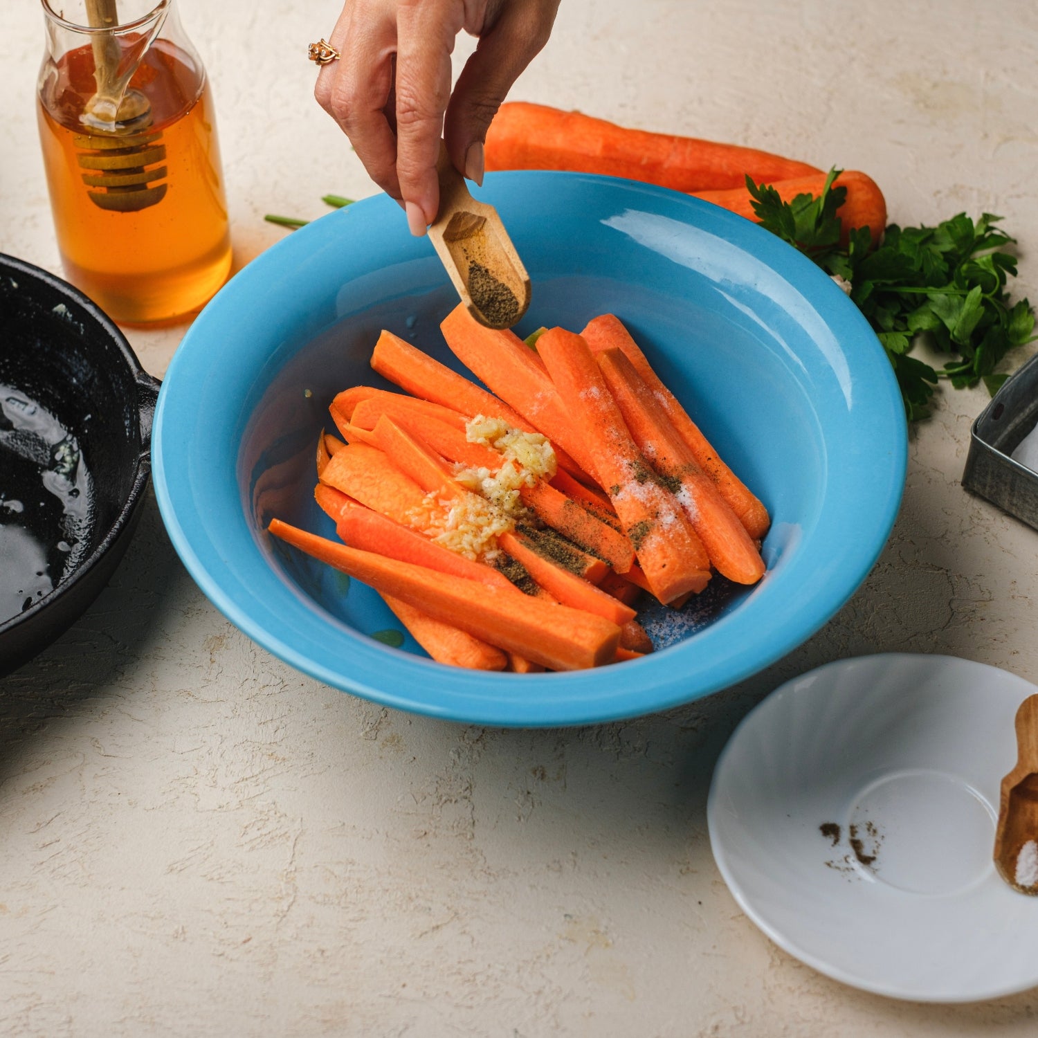 Carrots with seasoning in a blue bowl.