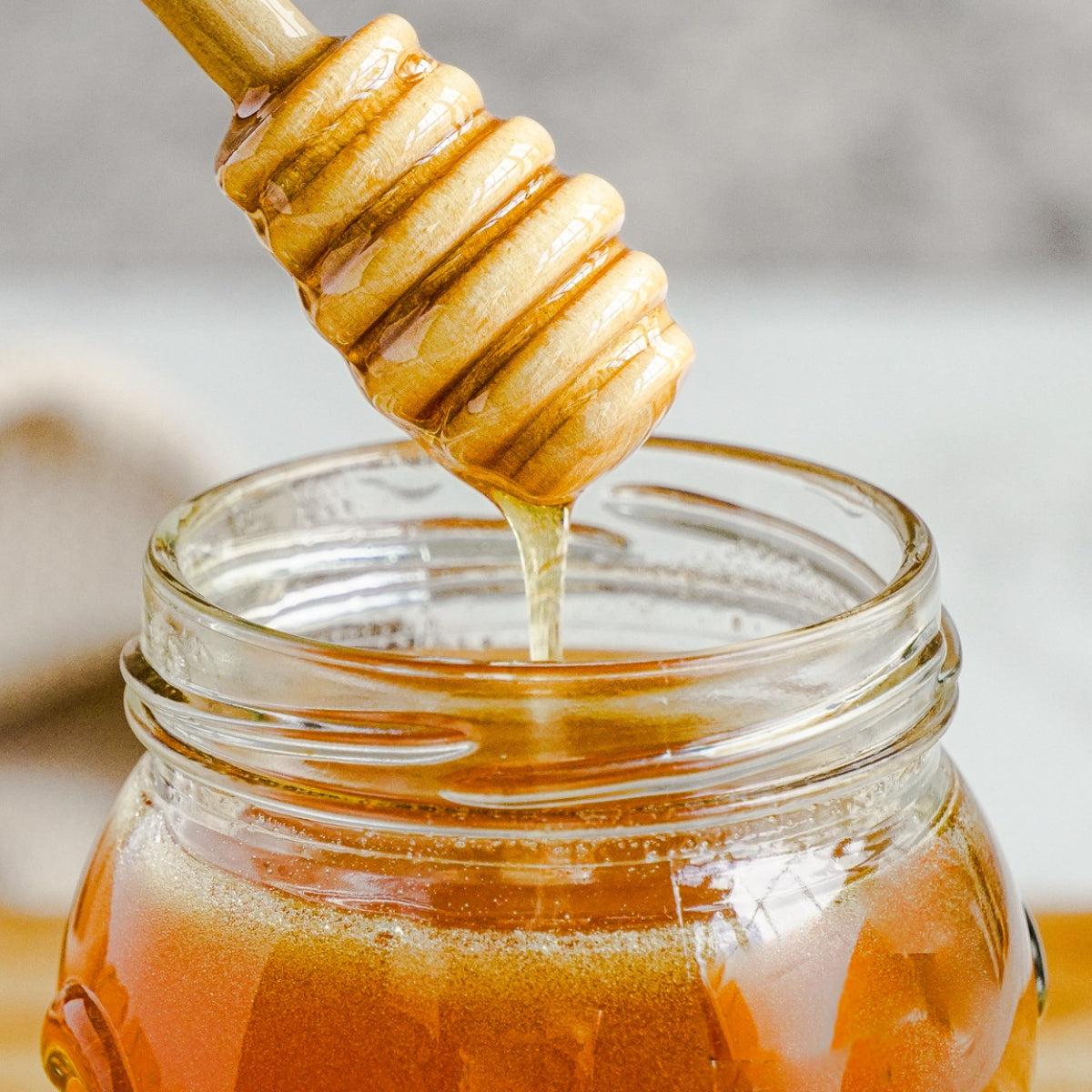 Hot honey being drizzled into a jar.