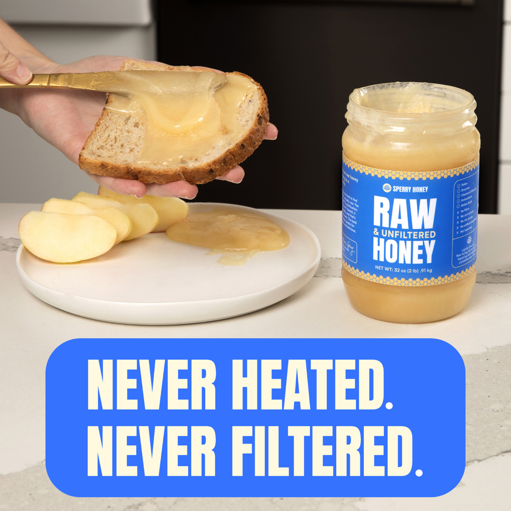 Person spreading raw unfiltered honey on bread with a jar of honey labeled 'Raw & Unfiltered Honey' in the background.