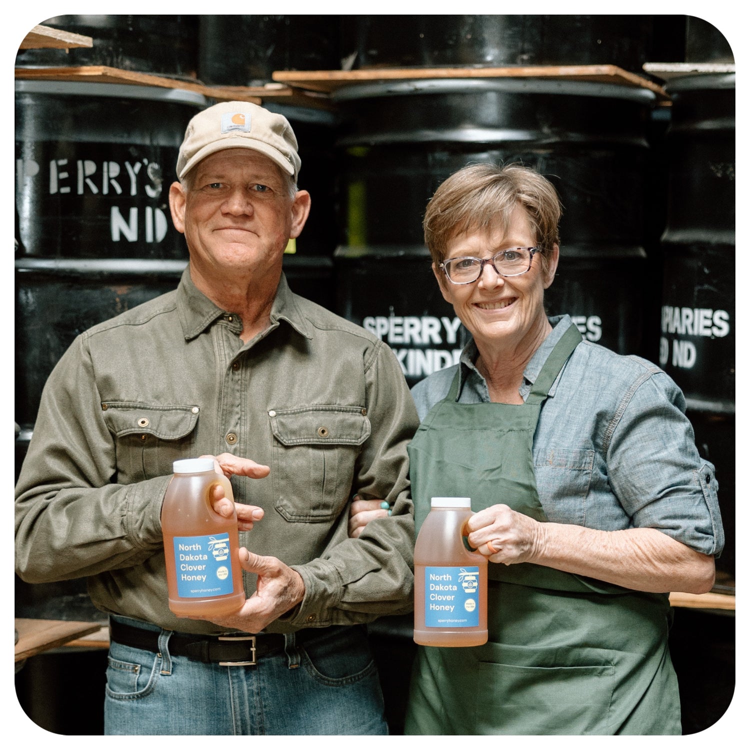 Mark and Becca Sperry holding jars of clover honey.