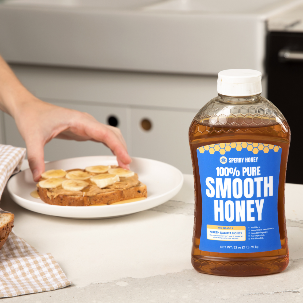 Bottle of Sperry Honey next to a plate with toast and bananas on a kitchen counter.