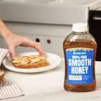 Bottle of Sperry Honey next to a plate with toast and bananas on a kitchen counter.