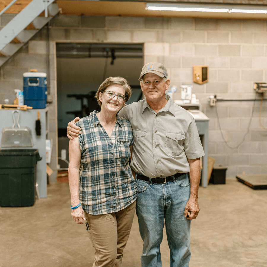 Mark and Becca Sperry smiling in their warehouse, where the beeswax is made.