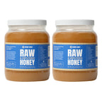Two large jars of Raw & Unfiltered Honey with white lids and blue labels, shown side by side on a white background.