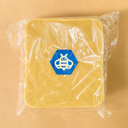 A packaged block of yellow beeswax.