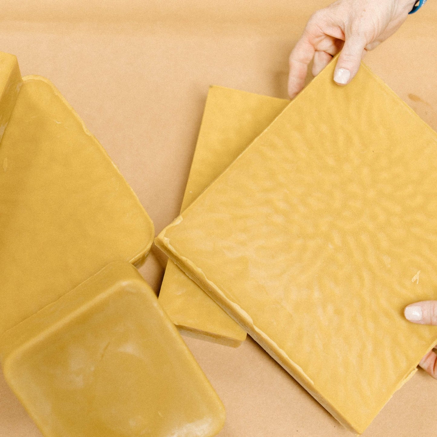 A pile of yellow beeswax blocks.